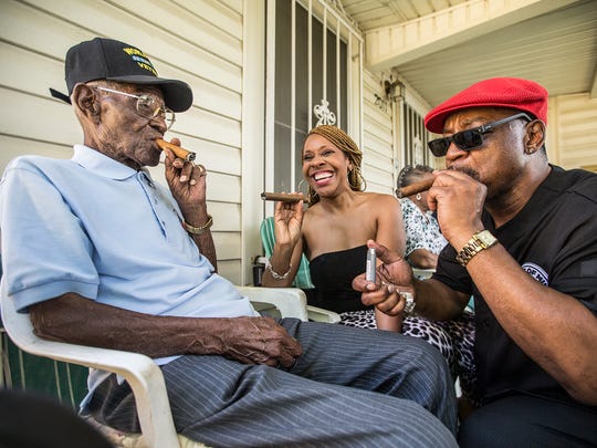 Richard Overton, left,  smokes a cigar with a few neighborhood