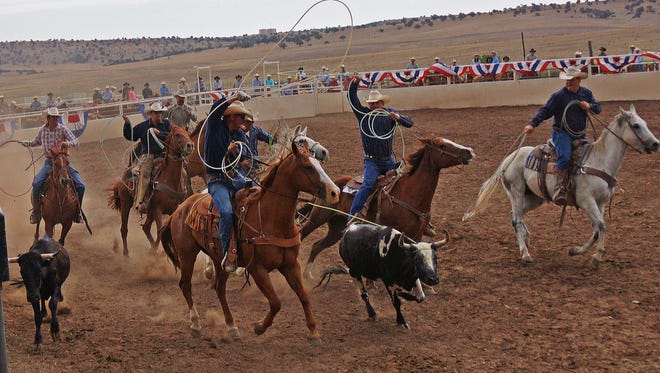 Cowboys competing in a team roping competition.