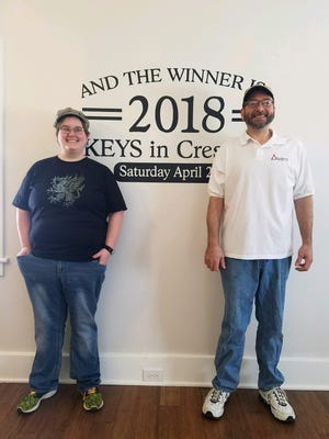 Dan Snyder (left) poses with daughter Meghan (right) inside his prize house. Snyder's ticket was the winner in St. Joseph Catholic Church's April 28 raffle drawing.