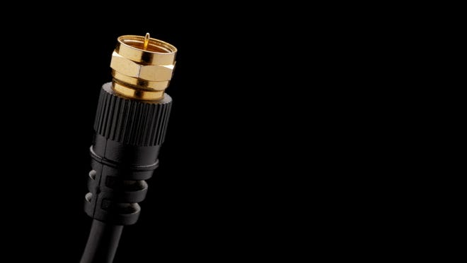 Close up of coaxial cable plug end over a black background