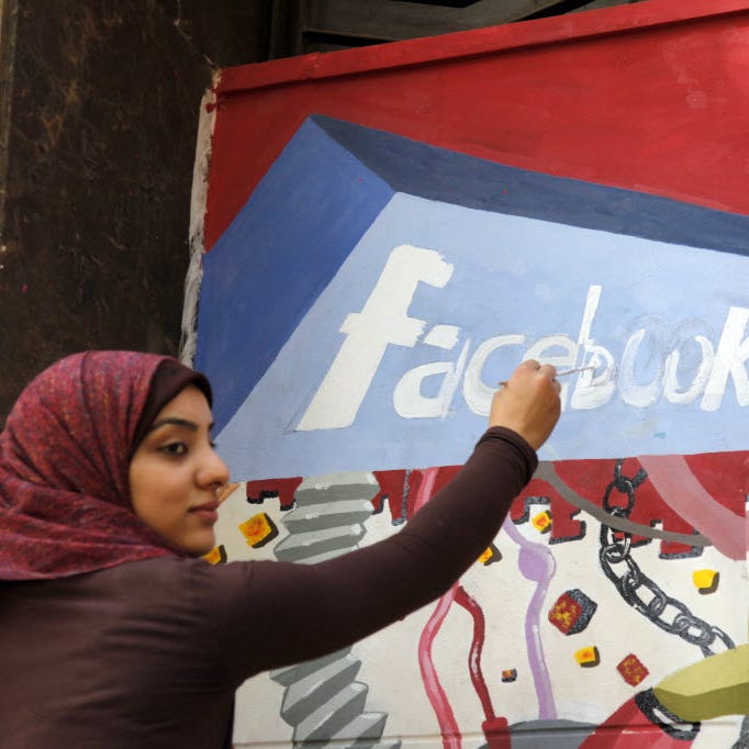 In this March 30, 2011 file photo. an art student from the University of Helwan paints the Facebook logo on a mural commemorating the revolution that overthrew Hosni Mubarak in the Zamalek neighborhood of Cairo, Egypt. In a statement to The Associate