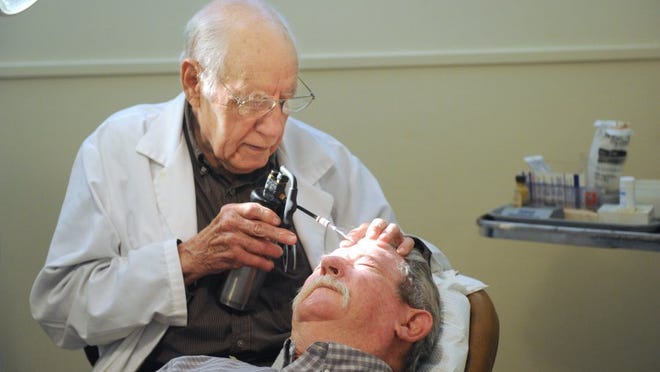 Nellie Doneva/Reporter-News Dr. Clyde Morgan, 92, treats some sun spots Aug. 15 on patient Danny Simpson, who has a history of skin cancer.