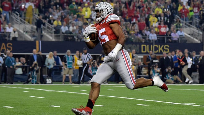 Ohio State Buckeyes running back Ezekiel Elliott (15) scores on a 33-yard touchdown run in the first quarter against the Oregon Ducks in the 2015 CFP National Championship Game at AT&T Stadium. Ohio State defeated Oregon 42-20.
