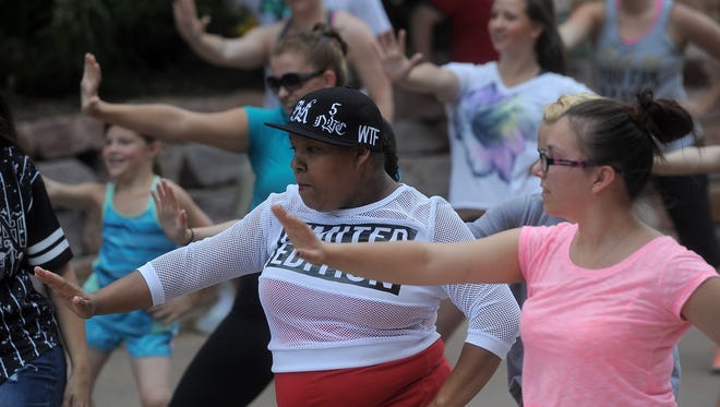 A flash mob forms in downtown Sioux Falls on Saturday. Devin Kistler arranged a flash mob to perform as a surprise before proposing to her girlfriend, Brooke Darling. Midwest Dance Center choreographed the flash mob and Kistler started practicing and preparing in April. Darling said "yes."