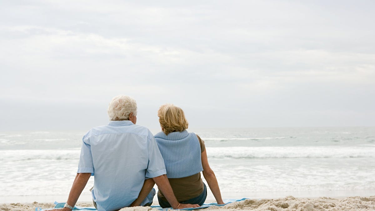 Two people sitting on the beach together.