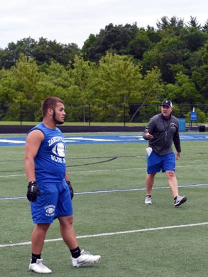 Zanesville assistant coach Dave Everson gives instruction to senior Caine Martin during Wednesday's summer team camp session at John D. Sulsberger Stadium. The Blue Devils have reached two Final Fours the past four years, but are coming off a 2-8 season.
