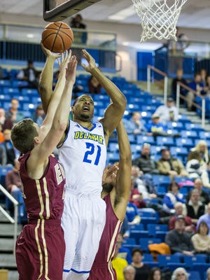 Delaware's Marvin King-Davis is sandwiched by two Elon players as he goes up for two points and is fouled.