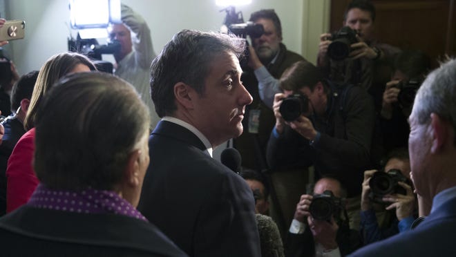 Michael Cohen, President Donald Trump's former lawyer, departs after speaking with the media after testifying before the House Oversight and Reform Committee, accompanied by his lawyers, Michael Monico, left, of Chicago and Lanny Davis of Washington, on Capitol Hill, Wednesday, Feb. 27, 2019, in Washington.