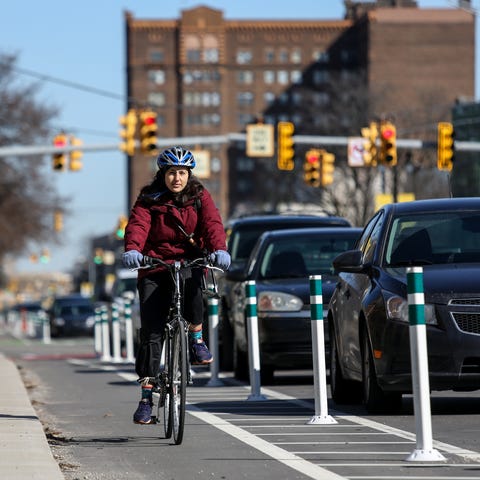 Bikers use the bike lane along Cass Avenue near...