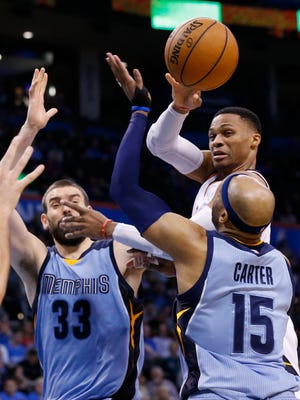 Oklahoma City Thunder guard Russell Westbrook passes between Memphis Grizzlies center Marc Gasol (33) and guard Vince Carter (15) during the fourth quarter of an NBA basketball game in Oklahoma City, Wednesday, Jan. 11, 2017. Westbrook posted his 18th triple-double of the season, and the Thunder won 103-95. (AP Photo/Sue Ogrocki)