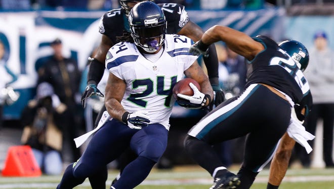 Dec 7, 2014; Philadelphia, PA, USA; Seattle Seahawks running back Marshawn Lynch (24) runs past Philadelphia Eagles strong safety Nate Allen (29) and defensive end Vinny Curry (75) during the first quarter at Lincoln Financial Field.