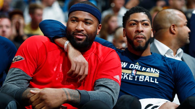 FILE - This April 7, 2017 file photo shows New Orleans Pelicans forwards DeMarcus Cousins, left, and Anthony Davis joking with each other as they sit on the bench and watch the second half of the team's NBA basketball game against the Denver Nuggets in Denver. The Pelicans' back-to-the-future experiment, centered on the All-Star front-court duo of Davis and Cousins, begins in earnest now. The stakes are high and immediate, because a third-straight non-playoff season could spell regime change, as well as an exodus of players, including Cousins, who are in the final season of their contract. Davis says Pelicans players know they’ve got “one year to basically figure it out.” Cousins says he senses a “special season” coming. (AP Photo/David Zalubowski, file)
