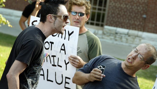 John Rusher (left) of Indianapolis takes exception to comments by Adam Briggs (wearing blue T-shirt), the pastor of the Damascus Road Bible Fellowship, and Richard Holst (holding a sign) at a rally at City Market in Downtown Indianapolis on Oct. 11, 2010. The rally was organized by LGBT groups to protest their treatment at the “Just Cookies” bakery at the market, but it attracted conservative protesters, too.