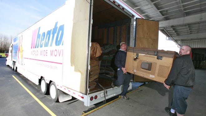 Moving truck drivers Michael Crawford (left) and  Troy Reffett unload a large television  in 2009.