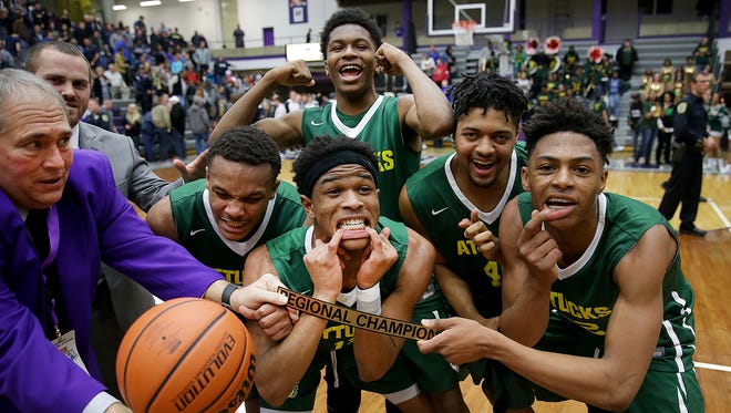 Crispus Attucks Tigers celebrate their win in the IHSAA Boys Regional championship game Saturday at the McAnally Center in Greencastle.