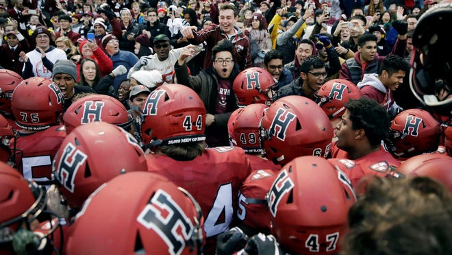 FILE - In this Nov. 17, 2018, file photo, Harvard players, students and fans celebrate their 45-27 win over Yale after an NCAA college football game at Fenway Park in Boston. Harvard defeated Yale. The Ivy League has canceled all fall sports because of the coronavirus pandemic.