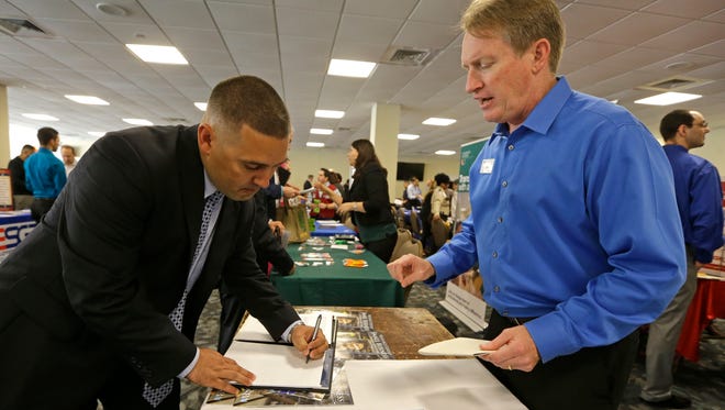 In this Friday, Feb. 6, 2015 photo,a U.S. Marine Corps veteran receives information at the annual Veterans Career and Resource Fair in Miami. The Labor Department's March job report showed the lowest unemployment rate in the U.S. since 2008.