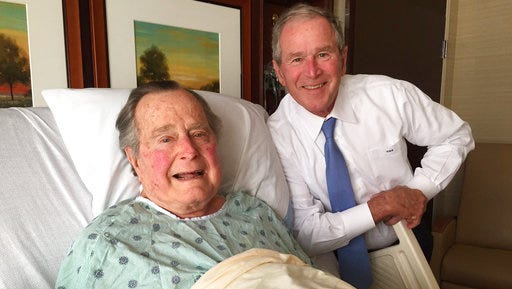 This Thursday, April 20, 2017, photo provided by the Office of George H.W. Bush shows former President George H.W. Bush, left, posing with his son former President George W. Bush at Houston Methodist Hospital in Houston where he is recovering from a mild case of pneumonia. He was admitted to the hospital Friday, April 14 for treatment of a persistent cough and doctors determined he had pneumonia.