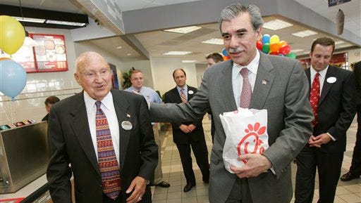 FILE - In this July 25, 2006, file photo, U.S. Secretary of Commerce Carlos Guiterrez, right, leaves with a lunch bag as Chick-fil-A founder S. Truett Cathy, left, walks him out after a meeting with Georgia business leaders to discuss immigration reform at Chick-fil-A in Atlanta. A spokesman said Cathy, who started a postwar diner in Atlanta that grew into the Chick-fil-A restaurant chain, died early Monday, Sept. 8, 2014. (AP Photo/John Amis, File)