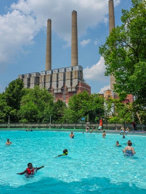 With the Eckert Power Station in the background, people enjoy being in Moores Park Pool in Lansing Sunday, June 17, 2018.