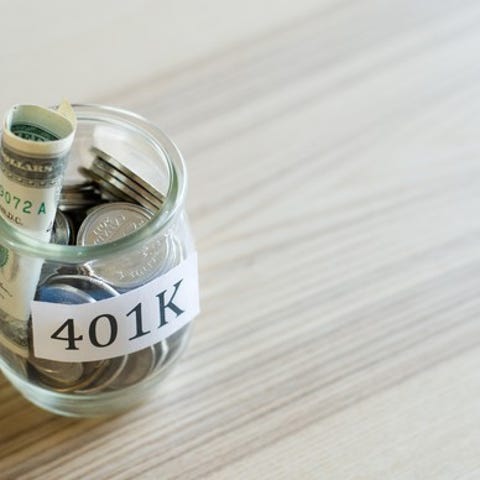 Glass jar labeled "401K" filled with rolled-up...