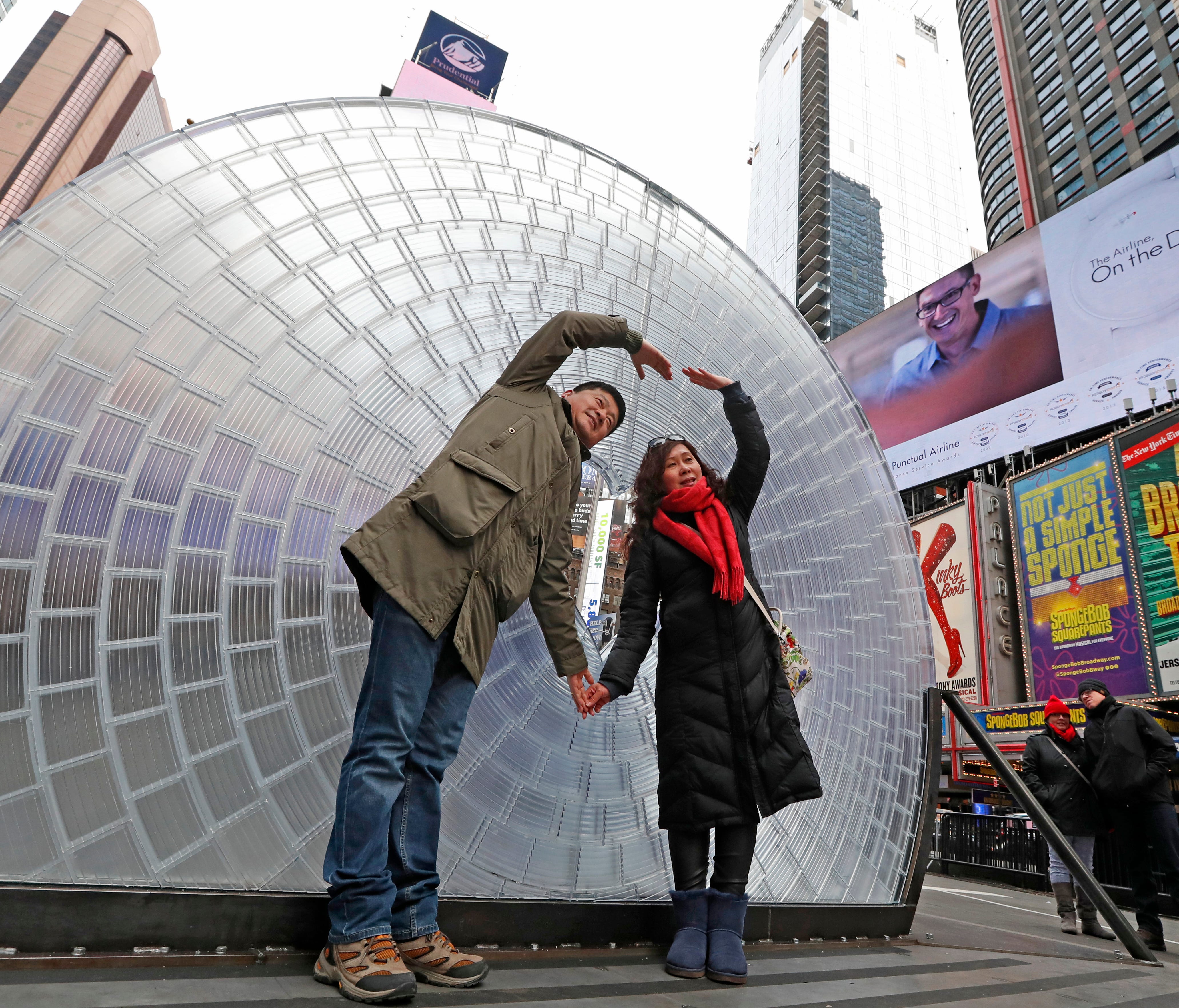 Chang Ming, left, and his wife Zhang Jin Hong, both of Tianjin, China, pose for a cell phone photo in front of 