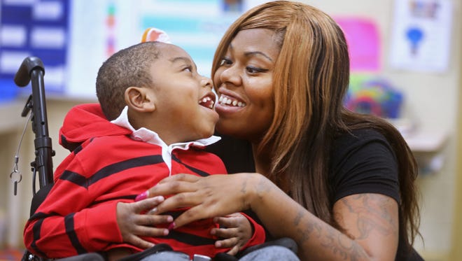Rasheim Foster, 5, gets some love from his mom, Melanie before kindergarten class at Bond Hill Elementary. Rasheim is one of the Enquirer's Wish List recipients. His mom is asking for a special stand-up chair to help him better interact with his classmates and siblings. Rasheim has cerebral palsy. Though insurance will pay for the wheelchair, they won't be for the stand-up chair. 