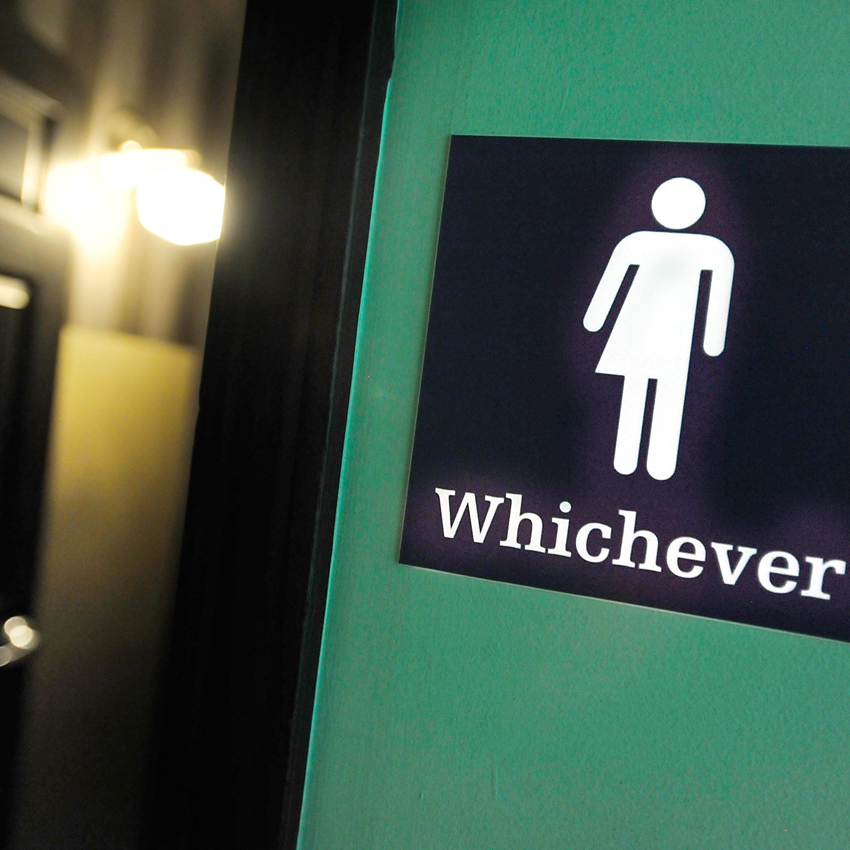 A gender neutral sign is posted outside a bathrooms at Oval Park Grill in Durham, North Carolina. Debate over transgender bathroom access has spreads nationwide.