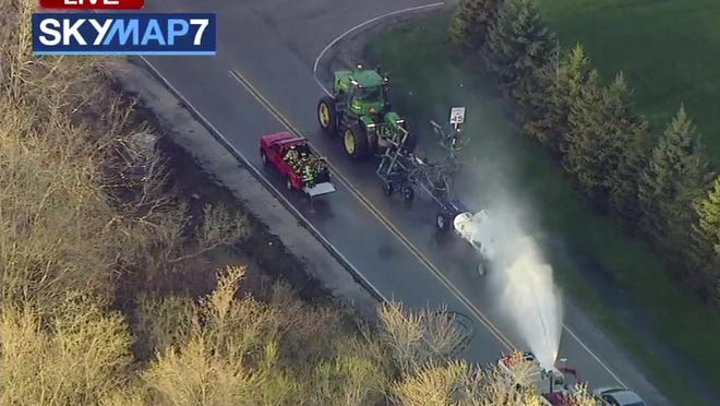 In this still image provided by ABC7 Chicago, a fire engine sprays water on a container of the chemical that farmers use for soil after after anhydrous ammonia leaked Thursday, April 25, 2019, in Beach Park, Ill. Authorities say dozens of people have been taken to hospitals.