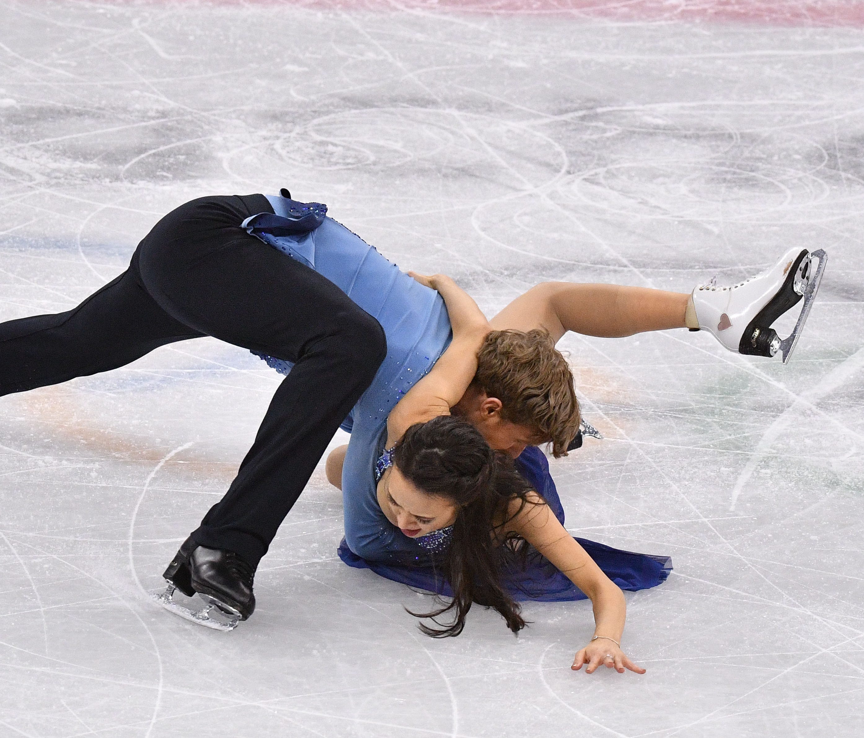Madison Chock and Evan Bates (USA) fall to the ice as they perform in ice dancing.