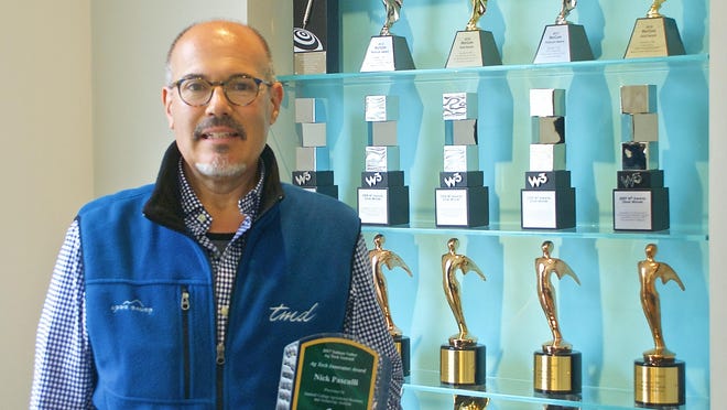 Nick Pasculli, president and founder of TMD Creative, holds the marketing company’s latest award at its offices on West Alisal Street in Salinas.