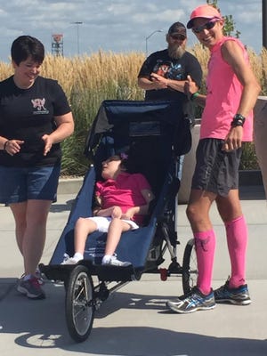 Shaun Evans stands with Amy Lingbeck after helping her daughter Haley,13, into her brand new freedom chair. Haley suffers from ohtahara syndrome, a rare seziure disorder that limits her mobility.