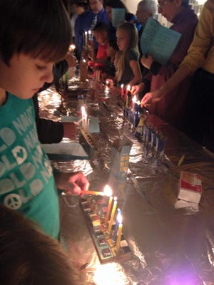 Families light menorahs, a custom of the eight-day Jewish festival of Hanukkah, during a 2014 celebration at Temple Beth-El in Las Cruces. The temple plans another community event this year on Dec. 11. A second congregation, Chabad, also will host a giant menorah lighting the evening of Dec. 6 in Mesilla to mark Hanukkah.
