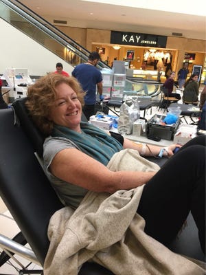 Laurie Connolly of Yorktown gives blood during the Yorktown field hockey team's blood drive at the Jefferson Valley Mall Saturday..