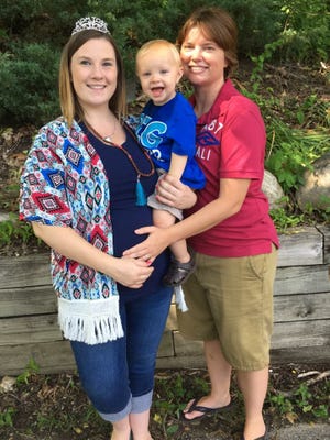 Ashlee Henderson, left, and her wife, Ruby Henderson, hold their son, Landon. A federal judge ruled in June 2016 that the Hendersons had a right to have both of their names on their son's birth certificate. The state has appealed that ruling.