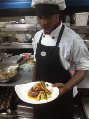 Desroy Clarke holds a plate of surf and turf he helped prepare as part of a Father's Day menu.