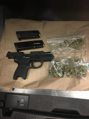 This photo shows a pistol stolen from Arizona and bags of marijuana seized when police say officers stopped two teens Wednesday.