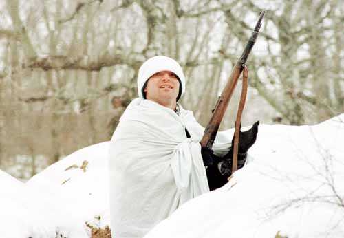 A Kosovo Liberation Army soldier, using a white sheet as camouflage for the snow, sits in a trench near the village of Lapastica, 30 miles north of Pristina on Monday. Serb rulers and ethnic Albanian rebels were under pressure to commit to peace talks, with envoys warning the rebels not to exhaust international goodwill and NATO tellng both sides the talks were their last chance.