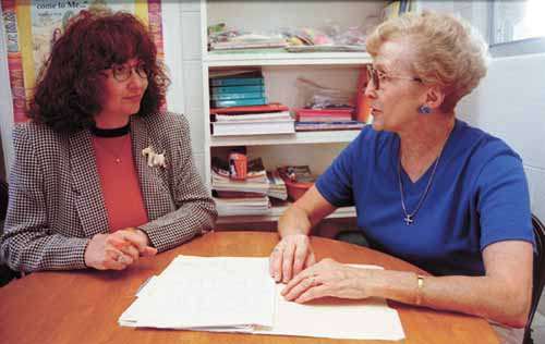 Judy Poitras, (right) secretary at the Tabitha Fellowship and Judy Kahler, (left) president of the Tabitha Fellowship go over the client list for the fellowship. The Tabitha Fellowship supplies daycare scholarships for needy women and their children so they can return to work or school and improve their job skills.