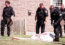 Barnstable police and Special Response Team members subdue David Letsch, 40, of Hyannis, after spraying his bedroom with pepper spray yesterday afternoon. Letsch held police delivering an arrest warrant at bay for two hours. The warrant sought to have Letsch undergo a psychiatric evaluation