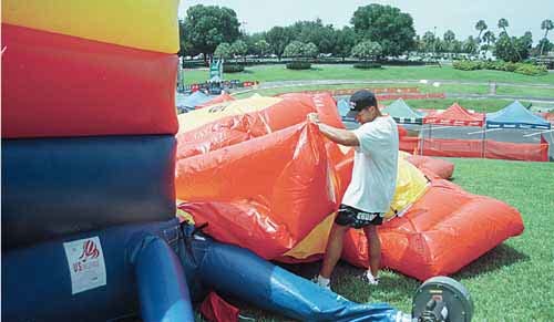 Jason Hoffman, events director for Extreme Sports Marketing, blows up the Nestle bounce house and slide for the Family Fitness Wekend being held today and Sunday at Cypress Gardens.