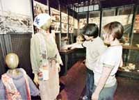 A Japanese couple looks at costumes worn by many people during World War II, at the Showa Hall war museum in Toyko. Many historical events embarassing to Japanese are not included in the museum.