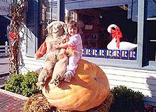 Thomas O'Hearn's granddaughter, Elena, sits on top of the giant 400-pound pumpkin that vanished from in front of O'Hearn's Cranberry Real Estate office building on Route 28 in Dennis Friday evening. The pumpkin's seeds are worth about $1 each among growers.