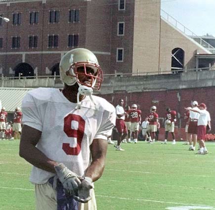 Florida State's Heisman Trophy hopeful Peter Warrick smiles as he puts on his gloves as he is allowed to practice with the team Tuesday, Oct. 19, 1999, in Tallahassee, Fla. Warrick is scheduled to appear in court Wednesday for a possible plea bargain deal on his felony grand theft charge. Warrick could play Saturday against Clemson in a deal that would send him to jail for a month early next year, the star receiver's lawyer said Tuesday. (AP Photo/Mark Foley)