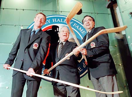 The newest members of the Hockey Hall of Fame, from left, Wayne Gretzky, Scotty Morrison and Andy Van Hellemond bask in the spotlight Monday in Toronto after induction ceremonies.