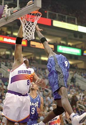 Phoenix Suns center Oliver Miller (8) slips in two of his season-high 17 points over Ben Wallace of the Orlando Magic during the first quarter of their NBA game, Tuesday, Dec. 7, 1999, in Phoenix. The Suns defeated the Magic 110-107.(AP Photo/Roy Dabner)