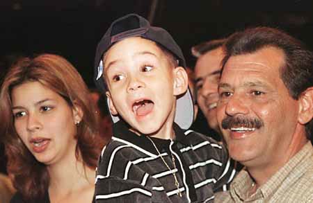 Elian Gonzalez, center, with his cousin Marisleysis, left, and great uncle Lazaro Gonzalez, right, enjoy the clowns at the Barnum and Bailey Circus at the Miami Arena Saturday. The family still waits for the decision of the INS and federal court on whether the 6-year-old Elian will be returned to his father in Cuba or allowed to stay with relatives in Miami.