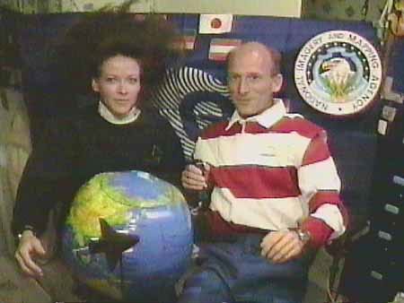 Astronaut Janet Kavandi, left, and German astronaut Gerhard Thiele use an inflatable globe and a shuttle model (visible on the front of the globe) for demonstration purposes during a televised interview from Endeavour's middeck Monday. The shuttle mission is collecting data for the most precise and complete 3-D map ever produced of the Earth.
