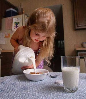 Four-year-old Alexandria Jansen adds milk to her cereal from a new three-quart milk bottle Tuesday at her parents' home in Gaithersburg, Md. The dairy industry, in an attempt to boost sales, has introduced a pitcher-like bottle to make pouring milk easier for young children.