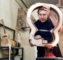 Marty Christian prepares to clean glue from a guitar hoop made of Brazillian Rosewood at Collings Guitars in Austin, Texas. The two strips of wood have been cut in bookmatch grain, formed under pressure and glued together in the mold surrounding the strips.